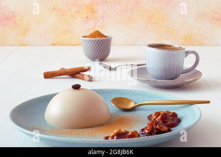 Espresso Panna Cotta mit Walnüssen in Karamell, Tasse Kaffee und Schüssel mit Zuckerrohr. Low-Angle-Ansicht. Stockfoto