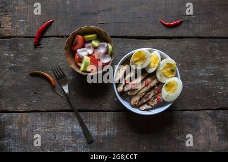 Blick von oben auf frisch zubereitetes caesar-Huhn und Eiersalat. Stockfoto