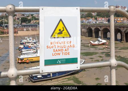 Ein Schild, auf dem auf Folkestone Harbour, Kent, vor weichem Schlamm und Sand gewarnt wird. Stockfoto