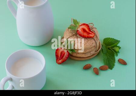 Süße Mandelgebäck auf einem Tisch. Hausgemachter französischer Keks. Nützliche Fastengebäck aus Mandelmehl mit Erdbeere und Minze auf grünem Hintergrund. Wählen Sie Stockfoto