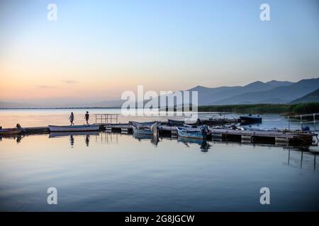 Ein junges Paar macht einen Abendspaziergang auf dem Ponton am Mikri Prespa See im Dorf Mikrolimni in Mazedonien, Nordgriechenland. Stockfoto