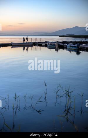 Ein junges Paar macht einen Abendspaziergang auf dem Ponton am Mikri Prespa See im Dorf Mikrolimni in Mazedonien, Nordgriechenland. Stockfoto