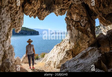 Ein Spaziergänger blickt über den Prespa-See in Richtung Albanien von einer Höhle am Ufer in der Nähe des Dorfes Psarades in Mazedonien, Nordgriechenland. Stockfoto