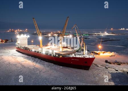 Sabetta, Region Tjumen, Russland - 07. Dezember 2020:das Schiff ist im Frachtbetrieb am Liegeplatz tätig. Das Schiff ist im Eis eingefroren. Stockfoto