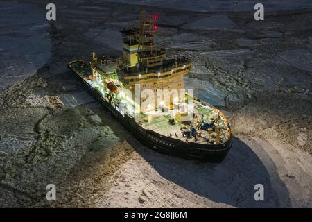 Sabetta, Region Tjumen, Russland - 04. Dezember 2020:der Eisbrecher liegt nachts im Eis. Der Eisbrecher leuchtet mit allen Lichtern. Stockfoto