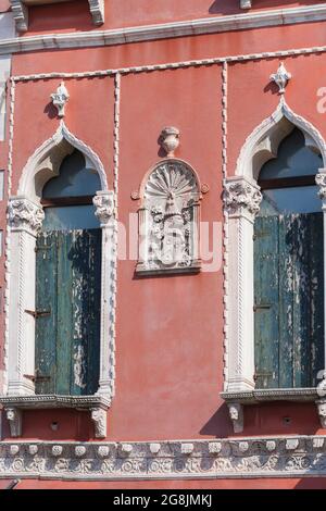 Architektonisches Detail an der Fassade eines Gebäudes zwischen zwei Fenstern im gotischen Stil am Canal Grande, Venedig, Italien Stockfoto
