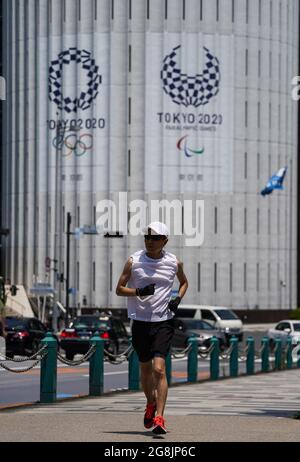 (210721) -- TOKYO, 21. Juli 2021 (Xinhua) -- EIN Mann joggt am Logo von Tokyo 2020 in der Innenstadt von Tokyo, Japan, 21. Juli 2021 vorbei. Die Olympischen Spiele 2020 in Tokio beginnen hier am Freitag. (Xinhua/Liu Dawei) Stockfoto