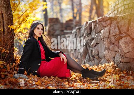 Junge schöne Frau posiert im Herbstlaub im Freien. Stockfoto