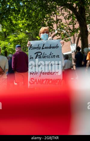 Demonstratin mit Schild: „ Israels Landraub in Palästina geht weiter - wir fordern Sanktionen “. Am 13. Juni 2020 haben sich bis zu Hundert Menschen zu einer Kundgebung und Mahnwache am Rotkreuzplatz in München sammelt, um gegen die Annexionspläne der israelischen Regierung von Benjamin Netanjahu und Benny Gantz der Westbank zu protestieren. (Foto: Alexander Pohl/Sipa USA) Quelle: SIPA USA/Alamy Live News Stockfoto