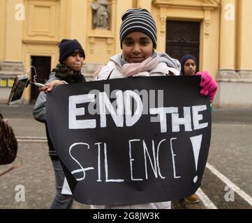 Junge Demonstratin mit einem Plakat mit der Aufschrift End The Silence! Zwei Dutzend Sudanesen und Sudanesen haben sich in München zusammengefunden, um Solidarität mit den Protesten im Sudan zu zeigen. The Prothest reciprod are goes to the Machthaber Umar al-Bashir. (Foto: Alexander Pohl/Sipa USA) Quelle: SIPA USA/Alamy Live News Stockfoto