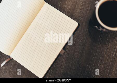 Notizbuch mit einer Tasse Kaffee und einem schönen Hintergrund Stockfoto