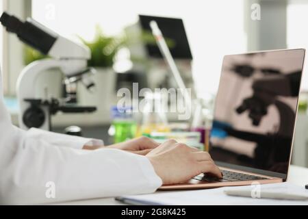 Wissenschaftler oder Student mit Laptop-Computer und Mikroskop. Online-Lernen Stockfoto