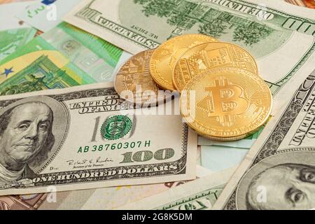 bitcoins auf einem Texturhintergrund aus Euro und Dollar Stockfoto