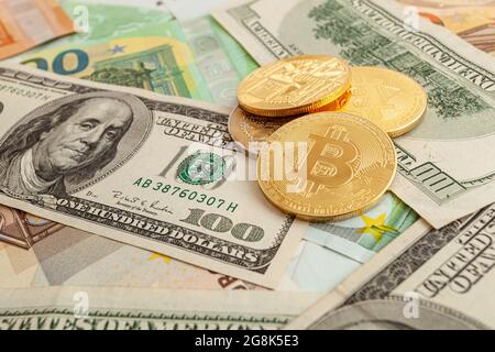bitcoins auf einem Texturhintergrund aus Euro und Dollar Stockfoto