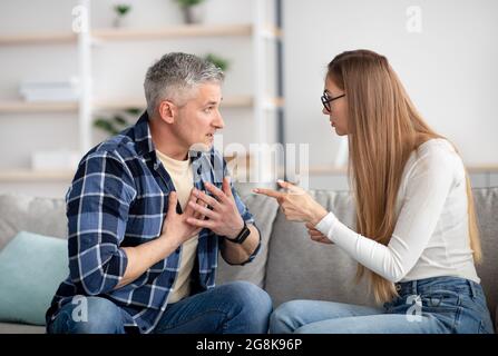 Gereizte, reife Frau, die sich zu Hause mit ihrem Mann streitete, wütend war und Probleme mit der Familie hatte Stockfoto