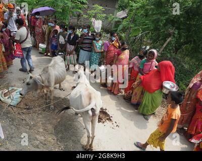 KALKUTTA, INDIEN - 30. Jun 2021: Sunderbans, Indien: Von Überschwemmungen betroffene Menschen treffen sich in que, um im Hilfslager in Sunderban, westbengalen, Nahrung zu erhalten. Stockfoto