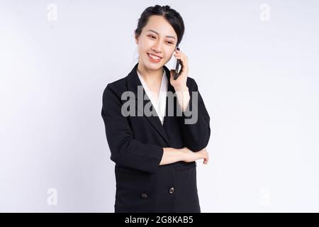Junge vietnamesische Angestellte in schwarzem Anzug, die fröhlich über die Ohh Stockfoto