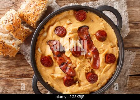 PEA-Mehlgachas-Manchegas mit Paprika serviert mit Speck und Chorizo-Nahaufnahme auf einem Teller auf dem Tisch. Horizontale Ansicht von oben Stockfoto