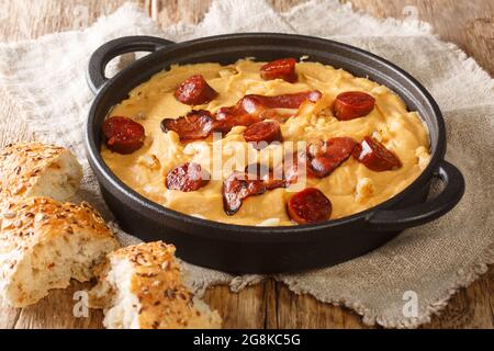 PEA-Püree mit Knoblauchspeck und Chorizo-Nahaufnahme in einer Pfanne auf dem Tisch. Horizontal Stockfoto