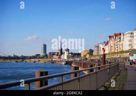 Rheinufer in Düsseldorf an einem sonnigen Tag mit blauem Himmel. Burgturm, Tonhalle (Konzertsaal) und Lambertus-Kirche im Hintergrund. Stockfoto