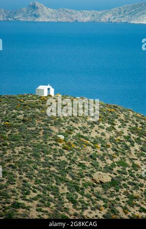 Anafi Island Griechenland dramatische, wunderschöne Küstenansicht einer kleinen traditionellen Kapelle auf einem Hügel mit Blick auf die beeindruckende Küstenlandschaft Stockfoto