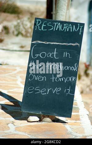 Anafi Island Greece Taverna-Menü auf einer Tafel einfaches, authentisches, nahrhaftes lokales Essen zum Mittagessen Vertikale Aufnahme mit verschwommenem Hintergrund für Stockfoto