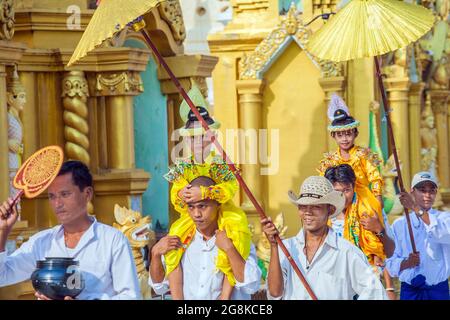 Junge Jungen werden zu ihrer Noviziationszeremonie für Shinbyu-Novizen in die Shwedagon Pagode, Yangon (Rangun), Myanmar (Burma) getragen Stockfoto