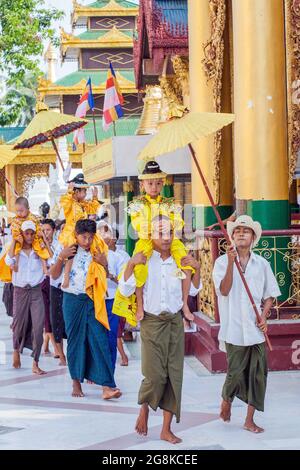 Junge Jungen werden zu ihrer Noviziationszeremonie für Shinbyu-Novizen in die Shwedagon Pagode, Yangon (Rangun), Myanmar (Burma) getragen Stockfoto