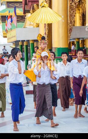 Der Junge wird für seine Novizierungszeremonie für Shinbyu-Novizen in der Shwedagon Pagode, Yangon (Rangun), Myanmar (Burma) getragen Stockfoto