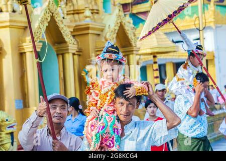 Junge Jungen werden zu ihrer Noviziationszeremonie für Shinbyu-Novizen in die Shwedagon Pagode, Yangon (Rangun), Myanmar (Burma) getragen Stockfoto