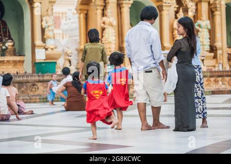 Junge burmesische Kinder laufen als Superheld Superman in Kostüm und Umhang, Shwedagon Pagode, Yangon, Myanmar herum Stockfoto