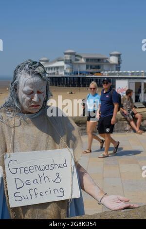 Weston-super-Mare, Somerset, Großbritannien. Juli 2021. In Weston-super-Mare werden Planungsvorschläge zur Erweiterung des Flughafens Bristol diskutiert. Die Demonstranten setzen sich aus Gründen des Klimawandels gegen die Expansion ein, bauen auf Grüngürtel und zunehmenden Verkehr. Bristol Airport Expansion Group ist eine Dachorganisation für lokale Extinction Rebellion und Klimafolgen. Diese Gruppe nennt sich Penitence und zwei Passanten sehen überrascht aus. Stockfoto