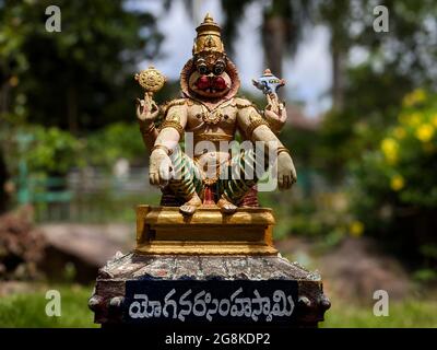 Nahansicht von Lord Sri Yoga narasimha swamy Idol isoliert im Natursteingarten in Tirumala: Tirumala, Andhra Pradesh, Indien-Juli 10.2021 Stockfoto