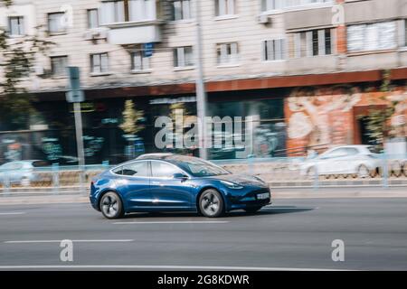 Ukraine, Kiew - 16. Juli 2021: Blaues TESLA Modell 3 Auto bewegt sich auf der Straße. Redaktionell Stockfoto