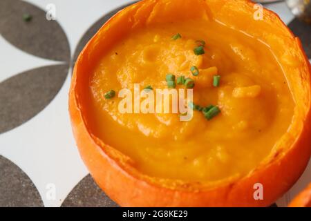 Curry Butternut-Kürbissuppe mit Kokosmilch. Vegane Kürbissuppe in einer Squashschale. Essen gesunde Konzept. Stockfoto