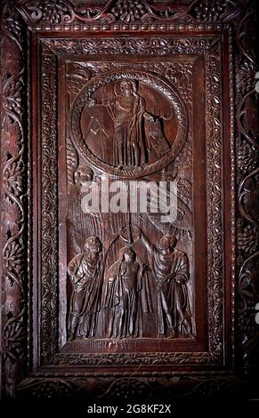 Rom Colle Aventino, Basilika Santa Sabina .insbesondere das große geschnitzte Zypressenportal, das aus dem 5. Jahrhundert stammt und perfekt erhalten ist, das erste Beispiel der christlichen Holzskulptur. Die achtzehn Tafeln, aus denen sie besteht, sind wirklich außergewöhnlich und stellen Szenen aus dem Alten und Neuen Testament dar. Man kann deutlich sehen, wie zwei verschiedene Künstler in der Tür arbeiten, einer ist klassizistischer mit einem hellenistischen Stempel, der andere hat Darstellungen von Volkskunst geschnitzt, darunter das erste erhaltene Bild von Christus, der zwischen den beiden Dieben gekreuzigt wurde. Geht und sucht die Szene des Durchgangs von Stockfoto