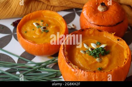 Kürbissuppe auf einem Tisch. Köstliche Herbstsuppe aus Karotten, Süßkartoffeln und Butternusskürbis. Comfort Food-Konzept. Stockfoto