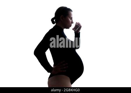 Studioaufnahme einer Schwangeren, die ein Glas Wasser trinkt Stockfoto