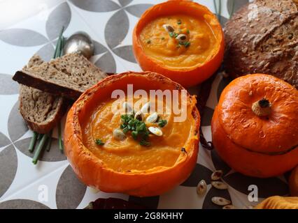 Cremige, nährende Butternut-Kürbissuppe mit einem Stück knusprigem Brot. Herbst comfort Food. Gesunde Ernährung Konzept. Stockfoto