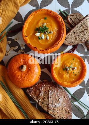 Cremige, nährende Butternut-Kürbissuppe mit einem Stück knusprigem Brot. Herbst comfort Food. Gesunde Ernährung Konzept. Stockfoto