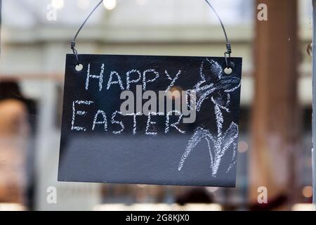 Die Inschrift Happy Easter ist in Kreide auf einer Schiefertafel geschrieben. Stockfoto