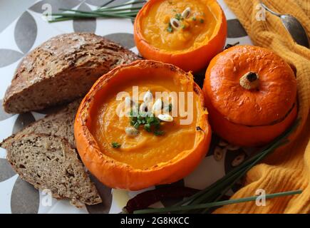 Cremige, nährende Butternut-Kürbissuppe mit einem Stück knusprigem Brot. Herbst comfort Food. Gesunde Ernährung Konzept. Stockfoto