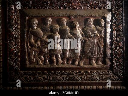 Rom Colle Aventino, Basilika Santa Sabina .insbesondere das große geschnitzte Zypressenportal, das aus dem 5. Jahrhundert stammt und perfekt erhalten ist, das erste Beispiel der christlichen Holzskulptur. Die achtzehn Tafeln, aus denen sie besteht, sind wirklich außergewöhnlich und stellen Szenen aus dem Alten und Neuen Testament dar. Man kann deutlich sehen, wie zwei verschiedene Künstler in der Tür arbeiten, einer ist klassizistischer mit einem hellenistischen Stempel, der andere hat Darstellungen von Volkskunst geschnitzt, darunter das erste erhaltene Bild von Christus, der zwischen den beiden Dieben gekreuzigt wurde. Geht und sucht die Szene des Durchgangs von Stockfoto