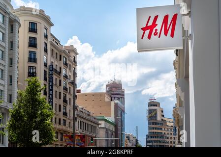 Madrid, Spanien - 18. Juni 2021: H&M Fashion Store in Gran Via gegen das Stadtbild. Die ikonische Allee von Madrid, die für seine Kinos und Geschäfte berühmt ist Stockfoto