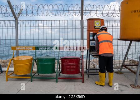DENPASAR, BALI-DEZ 24 2020: Ein Bauarbeiter ruht sich aus und wascht sich die Hände. COVID 19 macht die Menschen zu befolgen Gesundheitsprotokolle, einer von Stockfoto