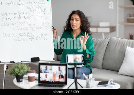 Die Lehrerin zeigte eine gute Geste und erklärte den Schülern Mathematik Stockfoto