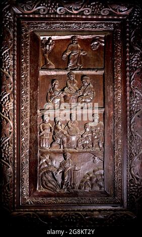 Rom Colle Aventino, Basilika Santa Sabina .insbesondere das große geschnitzte Zypressenportal, das aus dem 5. Jahrhundert stammt und perfekt erhalten ist, das erste Beispiel der christlichen Holzskulptur. Die achtzehn Tafeln, aus denen sie besteht, sind wirklich außergewöhnlich und stellen Szenen aus dem Alten und Neuen Testament dar. Man kann deutlich sehen, wie zwei verschiedene Künstler in der Tür arbeiten, einer ist klassizistischer mit einem hellenistischen Stempel, der andere hat Darstellungen von Volkskunst geschnitzt, darunter das erste erhaltene Bild von Christus, der zwischen den beiden Dieben gekreuzigt wurde. Geht und sucht die Szene des Durchgangs von Stockfoto