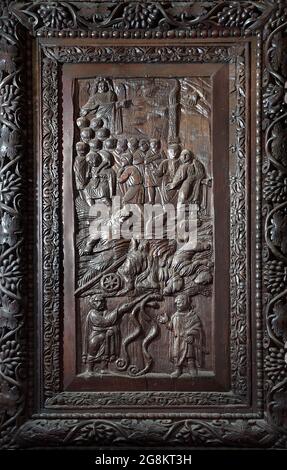 Rom Colle Aventino, Basilika Santa Sabina .insbesondere das große geschnitzte Zypressenportal, das aus dem 5. Jahrhundert stammt und perfekt erhalten ist, das erste Beispiel der christlichen Holzskulptur. Die achtzehn Tafeln, aus denen sie besteht, sind wirklich außergewöhnlich und stellen Szenen aus dem Alten und Neuen Testament dar. Man kann deutlich sehen, wie zwei verschiedene Künstler in der Tür arbeiten, einer ist klassizistischer mit einem hellenistischen Stempel, der andere hat Darstellungen von Volkskunst geschnitzt, darunter das erste erhaltene Bild von Christus, der zwischen den beiden Dieben gekreuzigt wurde. Geht und sucht die Szene des Durchgangs von Stockfoto