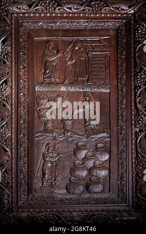 Rom Colle Aventino, Basilika Santa Sabina .insbesondere das große geschnitzte Zypressenportal, das aus dem 5. Jahrhundert stammt und perfekt erhalten ist, das erste Beispiel der christlichen Holzskulptur. Die achtzehn Tafeln, aus denen sie besteht, sind wirklich außergewöhnlich und stellen Szenen aus dem Alten und Neuen Testament dar. Man kann deutlich sehen, wie zwei verschiedene Künstler in der Tür arbeiten, einer ist klassizistischer mit einem hellenistischen Stempel, der andere hat Darstellungen von Volkskunst geschnitzt, darunter das erste erhaltene Bild von Christus, der zwischen den beiden Dieben gekreuzigt wurde. Geht und sucht die Szene des Durchgangs von Stockfoto