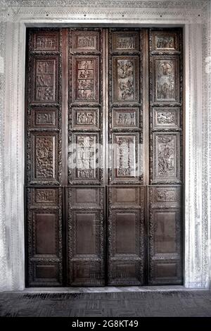 Rom Colle Aventino, Basilika Santa Sabina .das große geschnitzte Zypressenportal, das aus dem 5. Jahrhundert stammt und perfekt erhalten ist, ist das erste Beispiel der christlichen Holzskulptur. Die achtzehn Tafeln, aus denen sie besteht, sind wirklich außergewöhnlich und stellen Szenen aus dem Alten und Neuen Testament dar. Man kann deutlich sehen, wie zwei verschiedene Künstler in der Tür arbeiten, einer ist klassizistischer mit einem hellenistischen Stempel, der andere hat Darstellungen von Volkskunst geschnitzt, darunter das erste erhaltene Bild von Christus, der zwischen den beiden Dieben gekreuzigt wurde. Geht und sucht die Szene des Durchgangs des Roten Meeres Stockfoto
